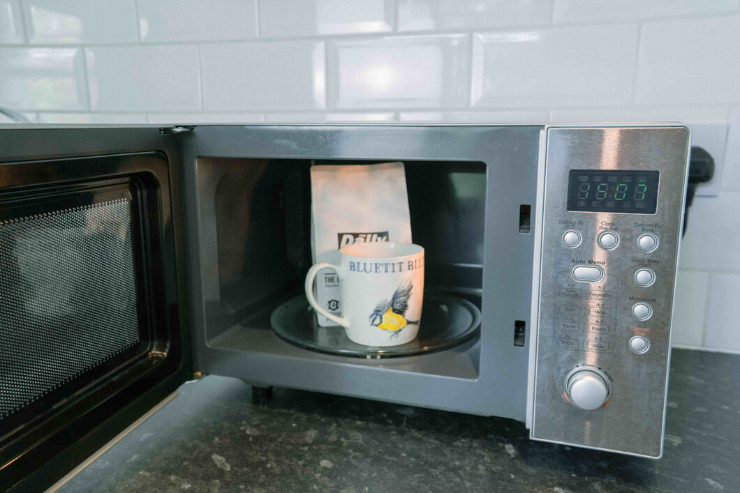Bag of coffee beans and coffee mug in a microwave