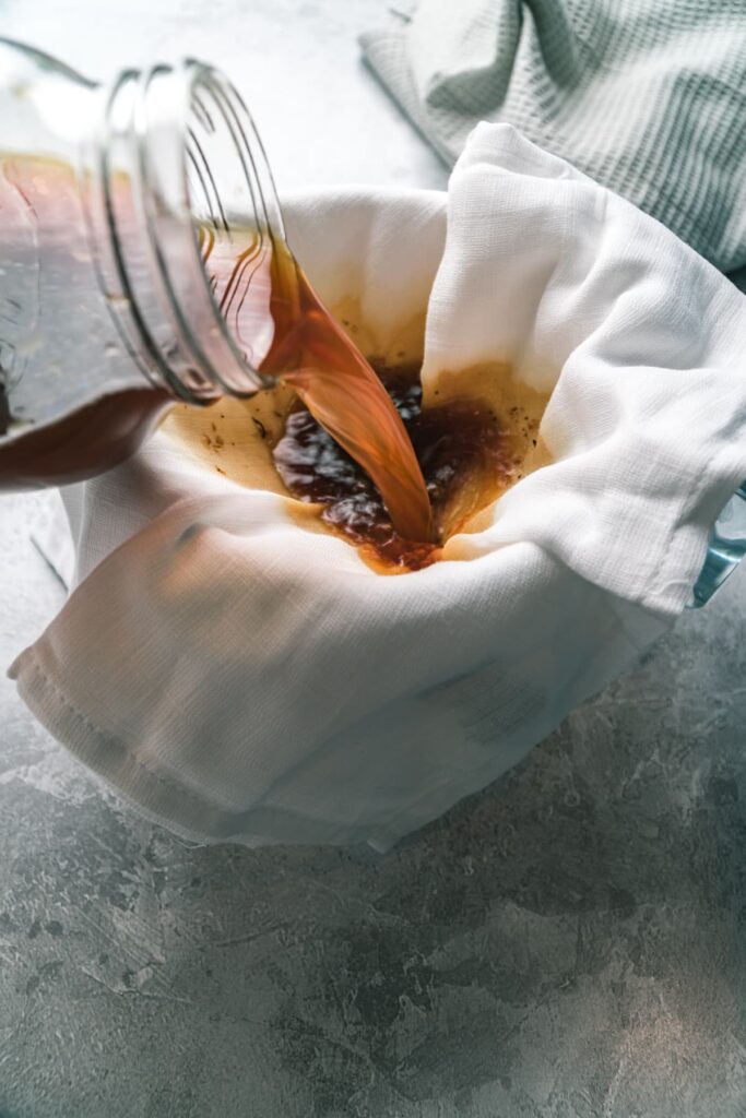 straining mason jar cold brew coffee